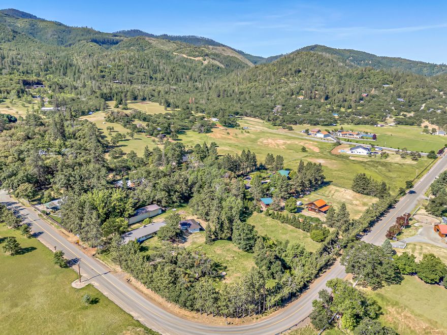 Opportunity knocks with this exceptional country property offering instant equity and endless potential. Live in the ADU while completely renovating the main house. Needs updating, but there is so much potential here! Ideal 2-family setup with two (2) separate homes, huge shop, private and peaceful, just minutes from Medford and Jacksonville. Usable acreage with mature trees, garden areas, ample parking, and a seasonal creek. Main home is 2201sqft, 4 bedrooms, 2 bathrooms, with a metal roof and attached oversized 2-car garage/shop, ready for your custom remodel. Permitted 570sqft ADU includes 1 bed, 1 bath, full kitchen, garage, and recent updates, great to live in while you renovate. Also includes a detached 1800sqft shop with power and thick concrete floors. Surrounded by high-end homes with three gated entrances off Dark Hollow. Priced to sell! High producing main well services the houses and additional well in the shop with wonderful sweet water used for irrigation (per seller).