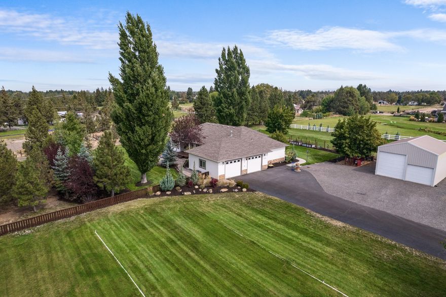 This well maintained and updated home offers a blend of indoor and outdoor living spaces, making it an ideal place to enjoy Central Oregon living. You will love the updates and care put into this home, it is truly turn-key.  The open concept great room features both formal and informal dining, vaulted ceilings, smart lighting and a well-appointed kitchen with hickory floors & cabinets, Jen-Aire appliances and quartz counters.   Single level living at its finest, the primary suite with access to the fully fenced back yard has lovely western exposure and a fully remodeled en-suite with curbless shower & custom tile work.  The professionally landscaped property with mature landscaping has a deer fenced garden with raised beds, a chicken coop, a 720 sq foot shop/rv garage, water feature and 1 acre of irrigation.  You can have it all, enjoy the convenience of city amenities while loving the benefits of a spacious lot with a country feel.