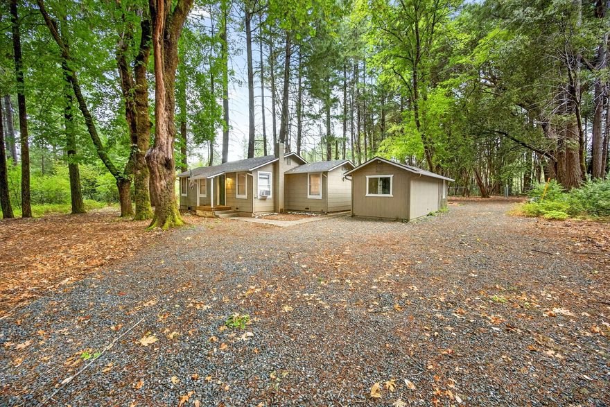 Welcome to this updated home that offers the peaceful feel of living in the woods while still being within walking distance of schools and shopping. Set on level acreage, the property is fully fenced around the home with a secure gated entrance, providing both privacy and space for pets, RVs, or trailers. Inside, enjoy a warm and inviting layout featuring newer granite kitchen counters, stainless steel kitchen appliances, laminate flooring, and a cozy pellet stove. The spacious bathroom includes a shower/tub combo with updated tile, mirror, and lighting. A detached building adds even more versatility with a large, finished room and closet-ideal for a potential ADU-plus, a separate workshop or storage area at the back. Move-in ready and full of possibilities!