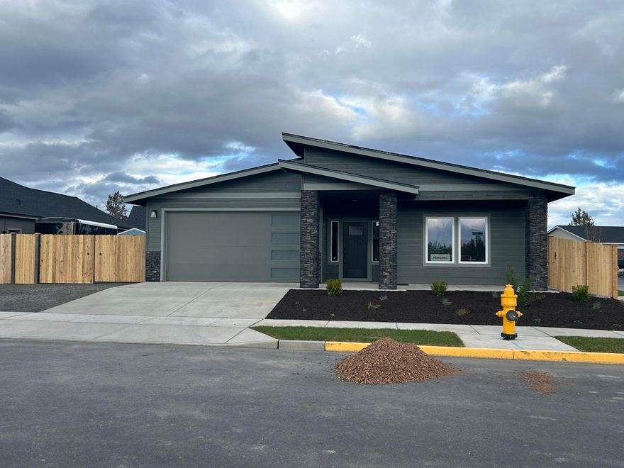 Welcome to Korbin Meadows, a new community in desirable neighborhood of SW Redmond. Lot 13 features the Juniper floorplan w/ single level living; 3 bdrms, 2 baths, 2 car garage & spacious side yard for RV/boat parking. Cascade mtn views from the covered front porch and front bedroom window.  Entertain in your kitchen w/ SS appliances, walk-in pantry, tiled backsplash, soft-close cabinets, extensive slab quartz countertops & large island opening to dining area and vaulted great room w/ decorative gas burning fireplace. Primary bdrm features a walk-in closet, dual vanity w/ shower. Two guest bedrooms share a full bath with double vanity. Utility/laundry room too! Durable laminate plank flooring thru-out & carpeted bdrms. Corner lot w/ fenced yard & landscaping w/ sprinklers & entrance gate. Upgraded finishes & A/C included! Est. completion April 2024. *Floorplan & rendering subject to change.