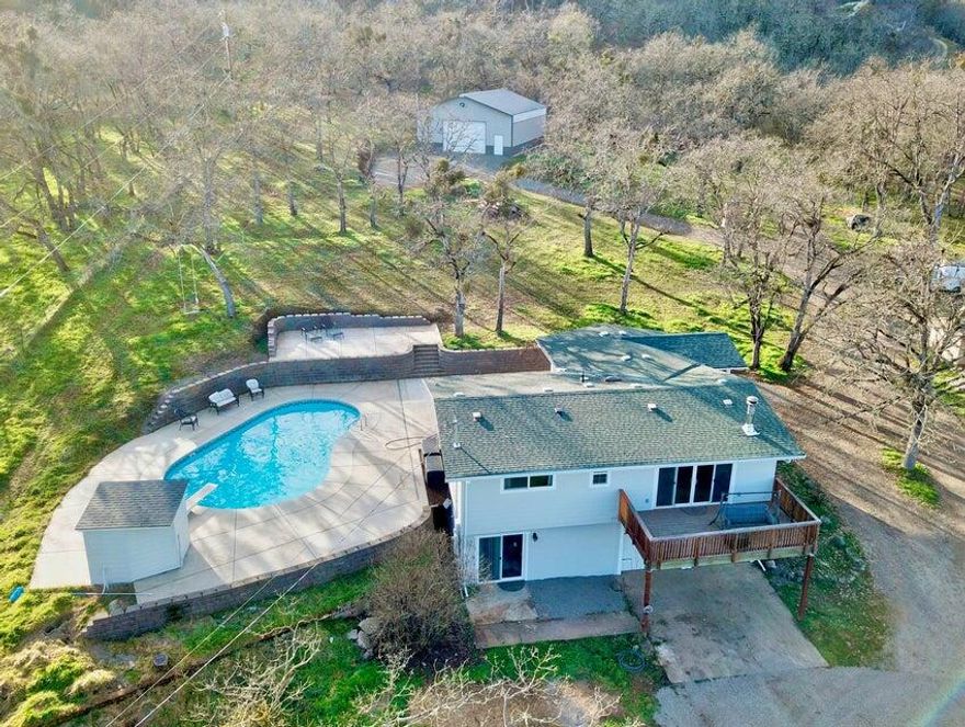 This one has it all! Nicely updated three-bedroom, two-bathroom home with primary suite on the lower level and two additional bedrooms, full bathroom, kitchen and living room on the main level. You will love the views off the front deck, or you can head out the back patio where you will find an inground pool complete with concrete sunbathing area. There is plenty of room on the 5.1 Acre property for raising chickens, goats or even keeping a horse. You will find a two stall horse barn with tack room and hay storage as well as a chicken coop. Saving the best for last, you will be thrilled to find a newly built 1,800 SqFt shop that is fully insulated, comes with 200 amp service and a 12 ft roll up door. This property has a little bit of everything! VA assumable loan at 3.625% interest rate!