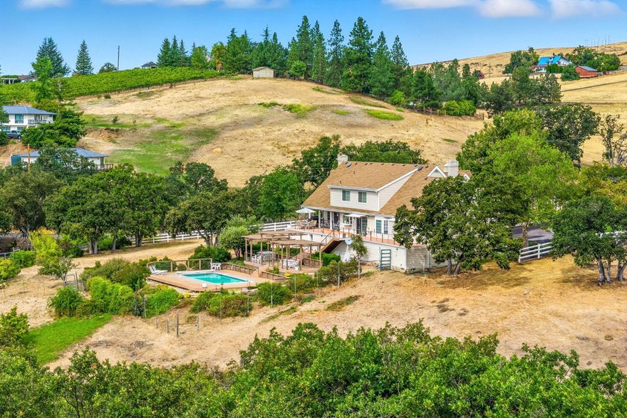 Incredibly desirable Ashland setting—private, quiet & close to town yet distinctly rural. On 5.09 acres with panoramic views of Mt. Ashland & the city, this 3566 sq ft 1985 home offers 5 bedrooms, 4.5 baths & two full primary suites, including a main-level retreat. The main floor features two sitting rooms with wood-burning fireplaces, a living room bar & a 2019 kitchen remodel with quartz leather-finish counters & painted cabinetry. Upstairs features two bedrooms with walk-in closets, a large bath & separate HVAC, plus a guest suite with a loft & window seat. Outdoor amenities: pool with Trex decking, gazebo, apple & plum trees, Gearky Creek, Talent Irrigation water & two workshops (50'x50' & 42'x36'). Other highlights: 2-car garage with workbench, wine cellar, auto generators, water softener, security system & abundant storage. Updates: roof, exterior paint, trellis, decking, railings, pool/spa (2018); HVAC (2019); blinds (2019); electrical/lighting (2018).