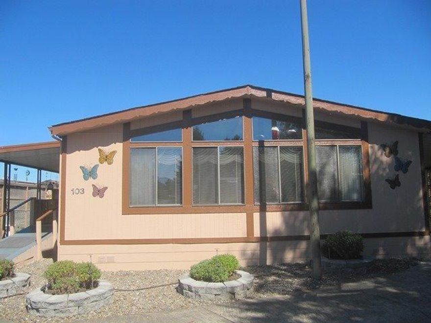 Recently updated 1990 doublewide in 55+ park! Newer carpet, vinyl, & paint within the last 3 years. Large covered deck recently added. All of this is sitting on one of the largest lots in the park. This clean & friendly park has a lovely clubhouse, including a pool, spa, and pool room. Space rent includes use of all common areas & garbage service.