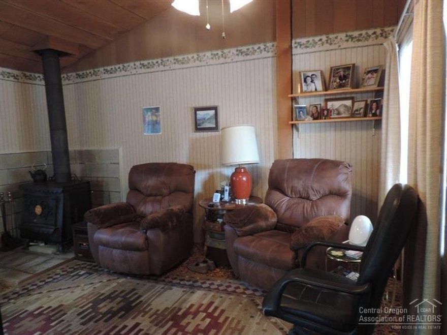 True 'Cabin in the Woods', but on paved road! Cozy and quaint. Carport added in 2013. Small Bunk House off back porch or additional storage. Great vacation spot to while away the hours watching the deer and swaying pine trees. Two outbuildings, one for storage & one for shop, plus full RV hookup! Partially fenced. Quiet area. Older well/septic, see att. documents. AS IS Property, a true fixer-upper!