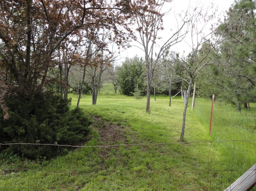 2 Bedroom 1 Bath Mobile Home tucked away in the trees on 15.42 Acres. Fenced on three sides of the front portion. Seasonal creek. Rolling hills and pasture on 3/4 of property. Well house with storage. 2 car carport 20X24 detached.