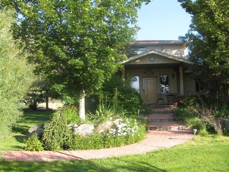 Custom home with 7.76 view acres with 4.8 of COI irrigation. Lush landscaping leads to covered porch, custom juniper door, tile floors in great room, log accents, propane fireplace w juniper hearth, radius windows, stainless steel appl, maple cabinets, slab granite counter tops, office extra lge utility room, tons of storage, lge deck wth log accents, wrought iron rail. Detached 906.5 sf garage shop. storage lean to shed w power, pump shed fenced and cross fenced pole barn hay storage.