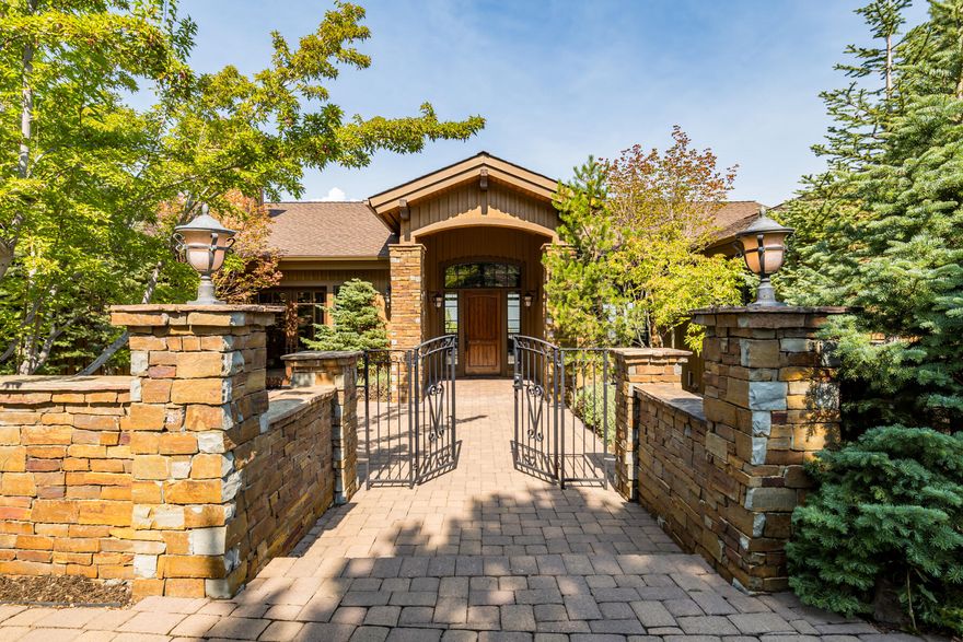 Nestled on a beautifully landscaped lot on one of Awbrey Butte's finest streets, this Mountain Modern home faces NW with panoramic views of the Cascade range. Covered patios on both levels maximize the views, visible from nearly every room. Enter through a gated stone courtyard with a water feature to a great room with vaulted ceilings, a floor-to-ceiling stone fireplace, and expansive windows that frame 180-degree mountain vistas. The gourmet kitchen features hickory floors, high-end Monogram appliances, a granite island, and Three Sisters views, while the dining area with wet bar opens to the deck for seamless indoor/outdoor living. In the primary suite, balcony access and sweeping views complement a soaking tub, heated bathroom floors, and a walk-in closet. Additional spaces include 3 guest bedrooms (2 en suites), a media room/home office with stone fireplace and courtyard access, a potential wine cellar, and a 3-car garage. Recently upgraded with new exterior paint and carpet.