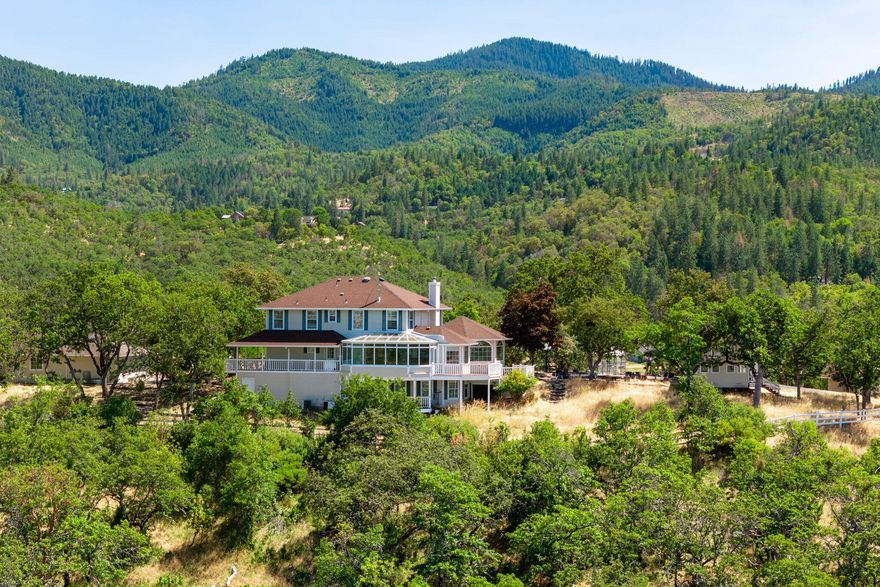 Southern Oregon Dream Ranch! Barn/shop, Playhouse & detached office w/loft space & slider & 4 car garage. Home sits up on a knoll that has amazing views of the Rogue Valley, & tons of windows to take in the views. Lg sunroom, Library w/ wood stove & built ins, wood floors. Kitchen with Cherrywood cabinet's w/pull outs, slate floors convection oven, 4 door refrige, dual fuel oven. Master on the main level, walk in closet, lg shower, sauna, dbl sinks, French doors to covered deck. Lg family rm upstairs w/2 bdrms & full bathroom w/claw foot tub tile floor and ½ bath. Lg laundry rm with laundry chute & storage. Downstairs would make a great work out rm or office with lots of windows & door to outside. Gated entry.