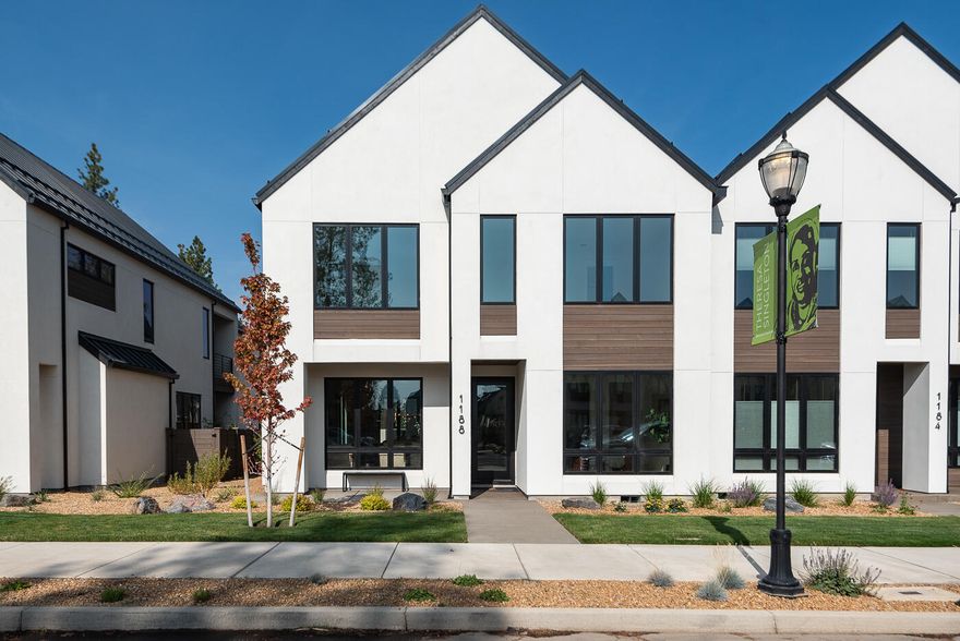 Scandinavian-inspired modern design with the award-winning craftsmanship of Structure Development NW in Discovery West. Trove Townhomes blend clean lines, contemporary finishes, and an open-concept layout, offering extraordinary living spaces. Great room with gas fireplace, custom built-ins and hardwood floors. Kitchen features professional appliances, large island and pantry. Dining area and covered patio are perfect for entertaining. Main level includes a guest suite, while the upper level is highlighted by a stunning primary suite with vaulted ceilings, tile shower, radiant floors and a large walk-in closet. Two additional bedrooms, full bath, loft, laundry room and covered deck complete the upper floor. Garage offers ample storage, and the fully landscaped yard enhances the home's curb appeal. Located just steps from Discovery Corner Plaza, a vibrant hub for shopping, dining, and neighborhood events. Embrace a carefree, active lifestyle in the heart of Discovery West.