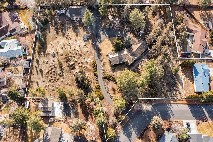 Invest in the future of Bend. Rare opportunity to own more than two acres with mature fruit trees in the heart of the Orchard District, a neighborhood currently experiencing revitalization. Spacious home with unlimited potential and complete privacy set back off the street. Recent updates include refurbished hardwood maple flooring, new fireplace with custom rock work, new furnace and water heater, and new lighting, cabinets, countertops, and range in the kitchen. A 30' x 40' shop offers a large upstairs loft and additional storage. The Orchard District is one of Bend's most diverse and fastest-growing communities, surrounded by parks and family-owned businesses, minutes from historic downtown. The area will directly benefit from the renewal of the adjoining Bend Central District, which is undergoing a transformation into a vibrant, walkable, bikable mixed-use neighborhood with safe connections between east and west Bend, including a planned pedestrian crossing at Hawthorne Avenue.