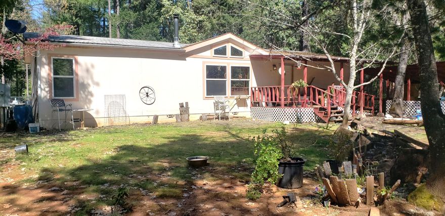 Peace & tranquility is this setting for 1997 mfg home with a very nice open floor plan. Central living with split bedroom design. Master has a large bathroom with a fiberglass walkin shower, 2 seats. Plus a big walk in closet. Kitchen and dining room combination, window over sink and a spacious pantry. There are several accessory buildings, including a double car garage, with concrete flooring. A really handy outdoor kitchen, for those who may enjoy canning and other activities. Little cabin'' needs some work. Well of record is 11 GPM when drilled. Extra holding tank for additional storage, for domestic water.  wheelchair ramps in place, front and back. Big back yard, some fencing in immediate area. Improvements sit back off main road, and plus, bordered by BLM on north boundary. 
Close to town conveniences, and 1 hour to beaches, on beautiful Oregon coast.