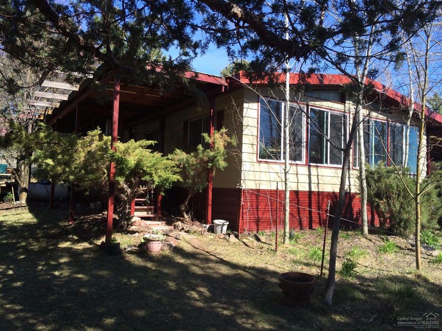 Well maintained house has a mountain view on a fully fenced lot. Insulated & wired workshop situated behind the home. Sun room & enclosed back porch provide extra living space. Large covered front deck. Separately fenced horse area with loafing shed & hay storage building. Mature trees and landscaping. The property borders Crooked River Ranch common area.