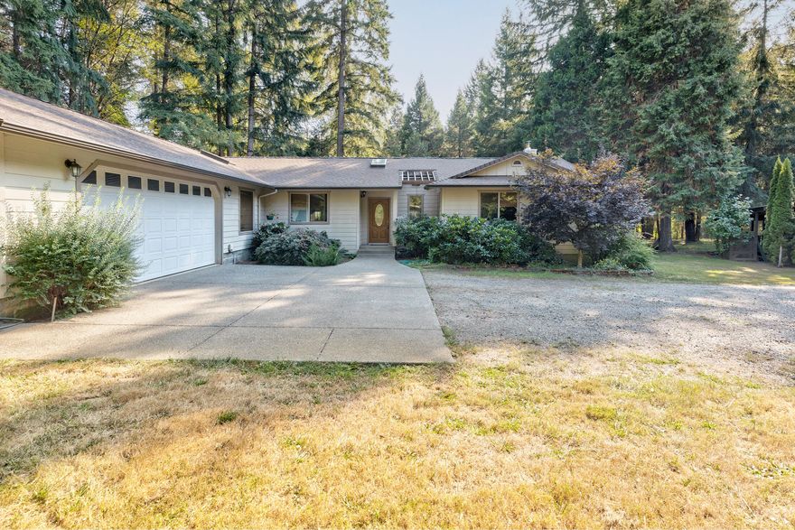 Get away from the hustle and bustle & enjoy the country life! Nestled amongst the tall trees and seasonal creek lays this comfortable well built 3 bedroom 2 bath home with attached 2 car garage and bonus shop space. All three bedrooms are situated in the floor plan for ultimate privacy. The primary features a walk in closet & functional standing shower with seat. The kitchen is light and bright with granite tile counters, eating bar & plenty of counter space. Open dining spaces leads to a step down living room with skylights & certified wood stove. Beyond the laundry room is the third bedroom, tucked away for guests or in-laws. Outside you will enjoy a large deck for entertaining, a storage building nicknamed the ''Llama Lounge'' as well as the bridge crossing the creek to the open barn and pasture area. There is possibility to divide the property as well-build your family compound or dream shop! All located within an easy approx. 30 min commute to Grants Pass or Roseburg. Call Today!