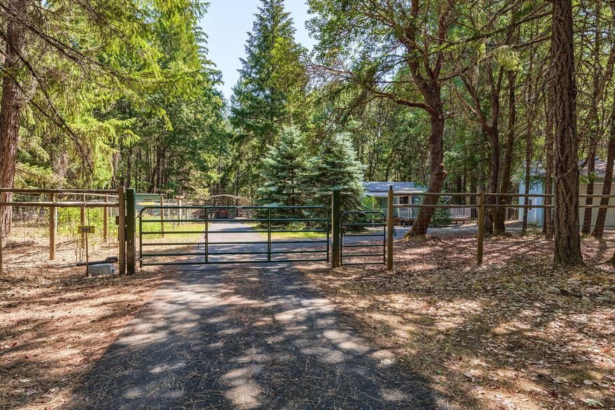 This 1992, Guerdon manufactured home sits on 2.51 wooded acres. 1188 square foot home offers two bedrooms and two bathrooms. In addition to forced air heat this home has a certified wood stove. Secondary bathroom has a walk-in tub. The front deck has a retractable awning. There are two storage sheds, a chicken coop and a very nice 440 square foot shop with roll up door. The detached carport can house two vehicles.  New roof is completed as of September 23, 2024.  In the winter/spring there is a seasonal run-off creek.