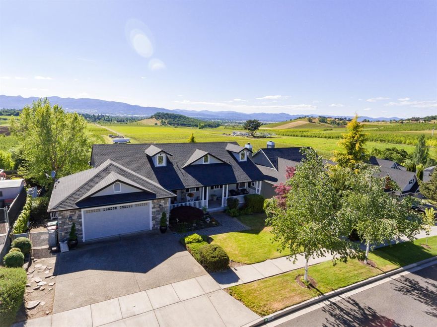 Simply put, this house offers some of the best views in Medford! Vineyards are your neighbors to the west, and sunsets are EPIC here! In the morning, enjoy the sunrise from your large front porch. Vaulted ceilings and dormers allow light to flow in from all sides. Solid maple flooring, gas fireplace, and many built-ins add to the warmth of this home. The kitchen is one of many highlights: granite counters, big island, Thermidor 6-burner range, dual ovens, and unobstructed views. French doors from the master bedroom open to the large upstairs deck. Inside, the master bath offers dual sinks, heated floors and slate tile shower. Custom cabinetry and much storage on both levels. Downstairs includes 2 bedrooms 2 bedrooms with built-in desks, large family room, full bathroom, and 9-foot ceilings. Custom blinds and solar shades help filter the summer sun, while a beautiful in-ground pool invites you to cool off. Even the downstairs provides great views!
