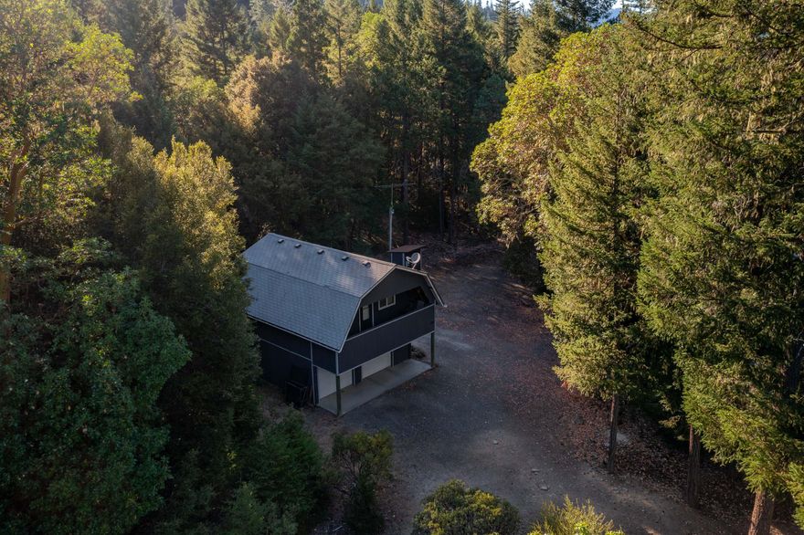 A true outdoorsman's retreat—this rare 7.36-acre parcel backs to thousands of acres of federal land, offering unmatched privacy and direct access to wild country. Towering old-growth timber, massive boulders, and a peaceful forest setting give this property a unique and rugged charm. Whether you're into hunting, hiking, or just looking for solitude in nature, this is the kind of place that's getting harder and harder to find. The 1-bedroom cabin-style home, built in 1997 above a two-car garage, is cozy, solid, and full of character—ideal as a full-time residence or a landing spot while you design your dream build. Private well with a newer pump (installed within the last 5 years), RV hookups, and BLM on two sides—this one stands out.