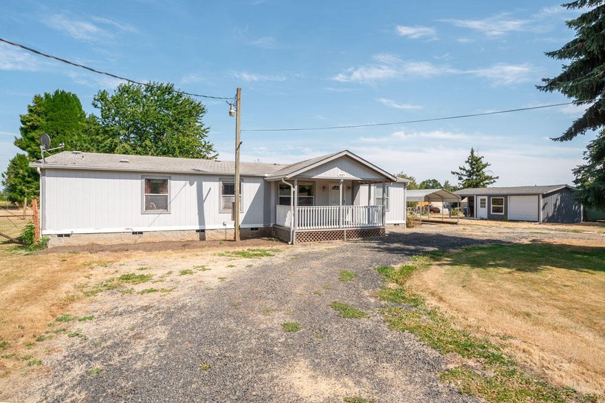 Enjoy living in the small community of Marion on 1.16 acres.  1564 SF Goldenwest doublewide with 3 bdrms, 2 baths.  Vaulted open floor plan; laminate and carpet flooring; convenient kitchen includes Range and Refrigerator.  Adjacent family room has propane fireplace. Heat Pump; Surround Sound;  Covered front porch and covered deck and patio for outdoor enjoyment.   Beautiful garden space,  12 raised beds;  blueberries; pear, cherry, plum and apple trees.  20 X 10 barn; 19 X 19 garage/shop;  Fenced pasture.  On well and septic.