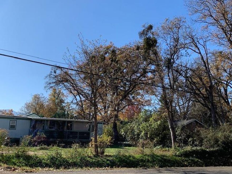 Attention builders and developers, large .49 acre lot with mature trees. Country feel but close to town. Connected to city sewer, city water is at the street per City of Medford. Singlewide mobile on the property is currently rented. Buyer to conduct Due Diligence for development potential.