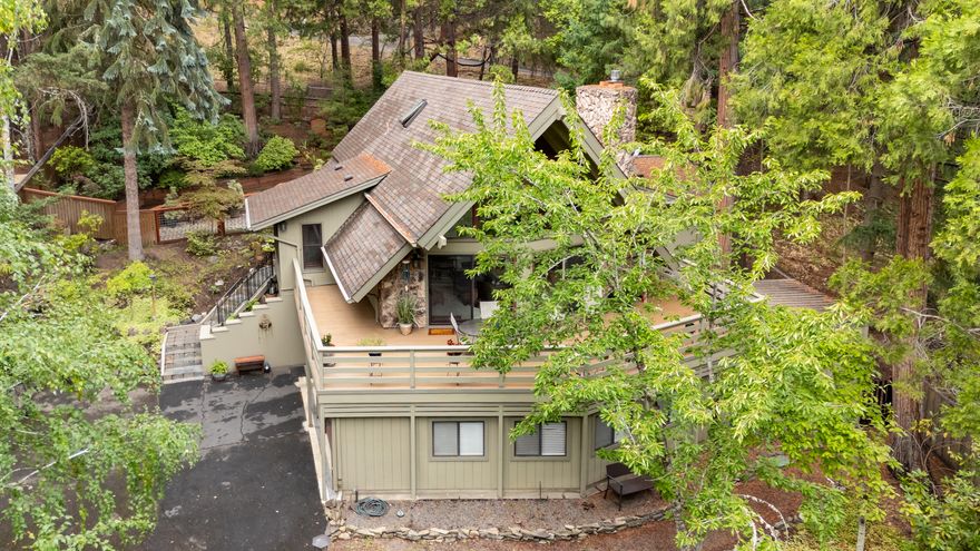 This storybook home blends timeless charm w/thoughtful updates in a private setting across from Lithia Park. Tucked back from Granite street on landscaped .36-acre TID-irrigated lot among cedars & dogwoods, it offers both tranquility & convenience. Light-filled living room w/floor-to-ceiling windows opens to a roomy deck, the perfect spot for enjoying the melodious sounds of Ash Creek winding through the park. The remodeled gourmet kitchen features custom cabinetry, leathered granite, tile backsplash, island w/microwave drawer, gas Wolf range & gas pizza oven. Two main-level bdrms open to a fenced yard with patio & enchanting gardens, while the upstairs master suite delights w/walls of windows & built-ins. The lower level provides laundry, 2-car garage, workshop, darkroom & bonus rooms. Detached flexible-use studio ideal for meditation, home office, hobbies. Moments from OR Shakespeare Fest, dining, skiing & trails, pickleball, Japanese gardens, this is a truly special & lovely home!