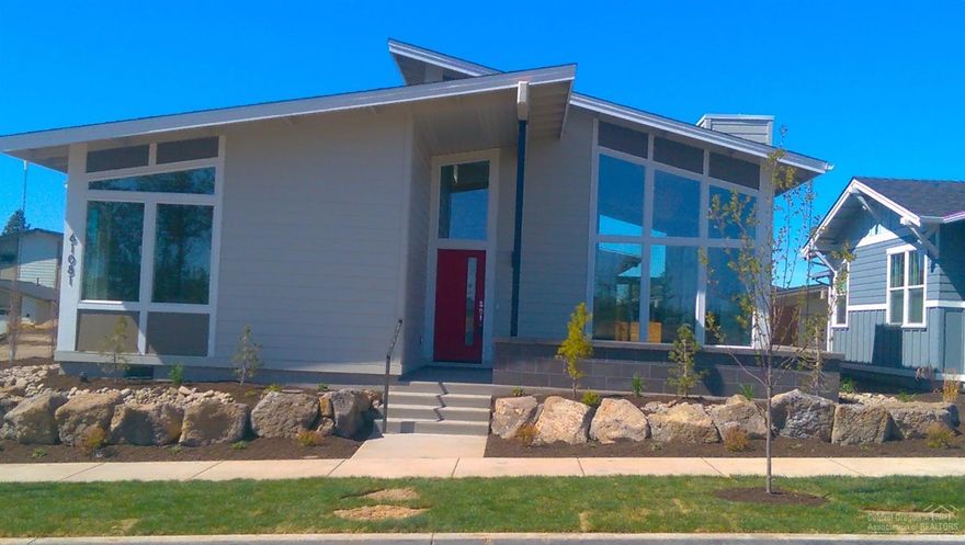 Stylish single-level Mid-Century Modern by JD Neel Construction features vaulted ceilings and bright rooms. Deluxe contemporary decor and finishes. Island kitchen and dining area face broad living area in great room. Central hall separates BRs from great room. Master suite in rear includes large walk-in closet and bath with dual sinks and walk-in tile shower. Courtyard patio w/ privacy wall and covered entry are at the front, sheltered side patio opens from dining area. Three-car garage w/ alley entrance.