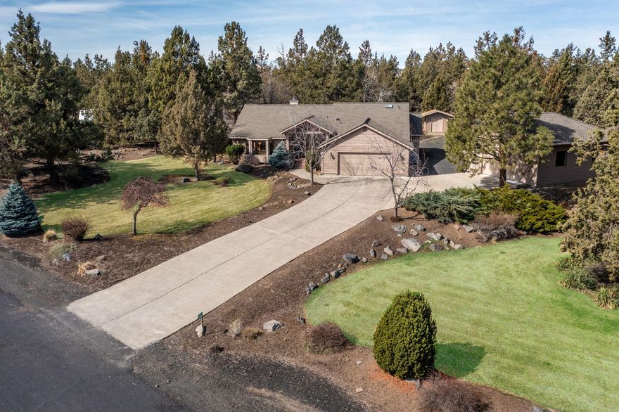 Nestled within a peaceful landscape, surrounded by mature trees on a spacious 1.15-acre lot. The kitchen has timeless wood flooring, has been tastefully updated with granite countertops, custom cabinetry, Kitchen Aid appliances, a wine bar, granite single-basin sink, & remote blinds. The primary bedroom boasts a soaking tub, tiled shower, heated flooring, and a generously sized walk-in closet. The hall bath features a tiled tub shower enclosure, heated flooring, and double vanities. Step outside to new exterior paint, an outdoor oasis complete with a paver patio and relaxing in the hot tub. The manicured lawns and garden area seamlessly transition into walking paths and nearby pickleball courts. A separate guest house, hobby room or 4th bedroom offers year-round comfort with heating and cooling, along with a kitchenette and 1/3 bath. Additionally, an insulated heated shop provides ample space for storing a large RV, or a standalone office that can easily be removed.