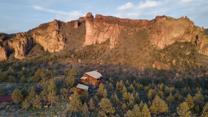 From this iconic, original Ranch at the Canyons basecamp you can plan your hike up Smith Rock, gear up for fly fishing, run the trails or go bird watching. Majestic 360 degree views of the Cascade Mountains, the Crooked River and Smith Rock's jagged ridge provides a heightened sensory experience beyond the property itself. Every room has a spectacular view, from the kitchen looking out to the vineyard, dining framed by rock spires, the primary suite's front row seat to Monkey Face, the guest bedroom's view of ponds, fields and Cascade Mountains. It just never gets old! This is also an incredible opportunity to own within the Ranch at the Canyons community, with 1700 acres, an equestrian center, 18 ponds, 8 miles of trails, 2 miles of river frontage, an event venue, and clubhouse with a pool, fitness center and guest suites. The pristine land attracts wildlife like bald eagles, otters, herons, owls, deer, beavers & more, and stargazing is unparalleled in this quiet night sky.