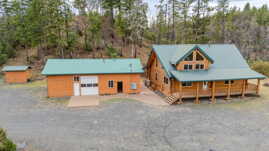 This stunning custom-built log home sits on nearly 40 timbered acres behind a gated entrance, offering the ultimate in secluded luxury living. The expansive open-beamed great room features soaring vaulted ceilings and amazing windows that frame breathtaking panoramic valley views. Cozy up to the certified wood stove on cool evenings, or enjoy your morning coffee on the wonderful, covered front or rear decks. The gourmet kitchen boasts beautiful granite countertops and a generous island perfect for entertaining, while a dedicated office area provides the ideal work-from-home space. 
Outside, discover endless possibilities with a large gardening area, a spacious 24x44 shop with guest quarters ideal for visitors, and ample parking. Bordering BLM land, this property provides direct access to unlimited outdoor recreation while maintaining complete privacy. Whether you're seeking a full-time retreat or weekend getaway, this exceptional log home delivers mountain living. AMAZING!