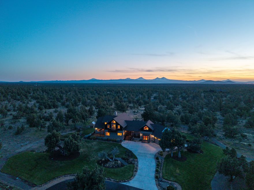 Highly Upgraded double primary custom home on 20 acres bordering BLM land w/Cascade Mountain views & a 5040sf shop w/insulated bonus space & bath. The home was recently repainted inside/out, has a 25kW PV solar system & solar heater for the hydronic radiant floor system, allowing low utilities. Upon entering the great room, the vaulted ceilings, exposed beams, & hardwood floors welcome you into this tranquil & well thought out retreat. Gourmet kitchen appointments w/Wolf double oven/range & fridge along w/expansive premium surfaces & ample storage highlight the space.  The primary suite has a living room, fireplace, 2 closets, & tiled shower. The guest ensuite is above the garage that has in-floor heat & a workout room. The detached shop has a well-appointed insulated bonus space/bath, 4 stalls, & 2-14' roll-up doors on each end of the 84' expanse. Livestock fencing is in place. The landscaping is perfect & the covered back deck leads to the patio w/hot tub & firepit.