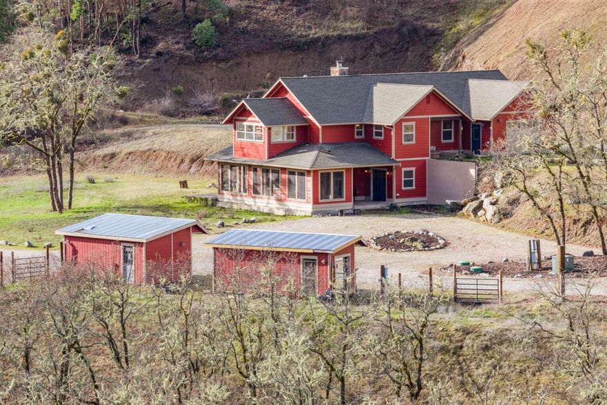 Beautiful custom home on 80 acres in sunny Southern Oregon. Property sits above the valley fog line and has many sunny days even in winter. Home has 2 primary suites, solid wood trim throughout, solid wood and stained concrete flooring, granite kitchen countertops, lots of windows for natural light, a screened in front porch, custom gun room, and much more. Home was constructed with materials sourced from the property (see pictures of large stone wood burning fireplace and flooring, trim window casements). Outdoors has lots of parking/rocked area for equipment and material storage, irrigated pasture, fenced area for animals, 2 ponds, 2 wells, gold and fish bearing year-round creek, mature timber, historic mine tailings, etc. Multiple outbuildings - large, insulated 2-story shop, 2 light dep greenhouses, dog kennel, chicken coop, UTV garage. Excellent hunting, hiking, horseback riding opportunities. This property is the ideal self-sustaining homestead!