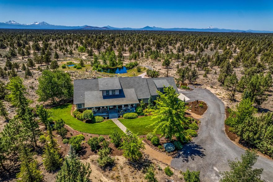This is a beautifully crafted custom home nestled into the most pristine landscaped 20 acres, bordering BLM. Home is 3,638 sq. feet & includes a ground floor master bedroom w/access to a private exterior deck capturing a panoramic Cascade Mtn View.  Also, on the ground floor you'll find kitchen, pantry, living, dining, guest bath as well as a large mud/laundry room. Exterior deck also Westward facing captures the big Mtn Views & overlooks 2 ponds connected by a trickling water feature. Upstairs: junior master suite as well as a 3rd bedroom, full bath & bonus room. Both upstairs bedrooms have private west facing balconies.  Don't miss the HUGE bonus room above the attached garage! This is a thoughtfully designed home w/great bedroom separation, storage galore & great work/school from home capabilities. Home comes complete w/an interior fire protection (sprinkler) system. Outside: detached garage w/great storage above & 2 fenced garden areas. 300+ trees/schrubs on automated irrigation!