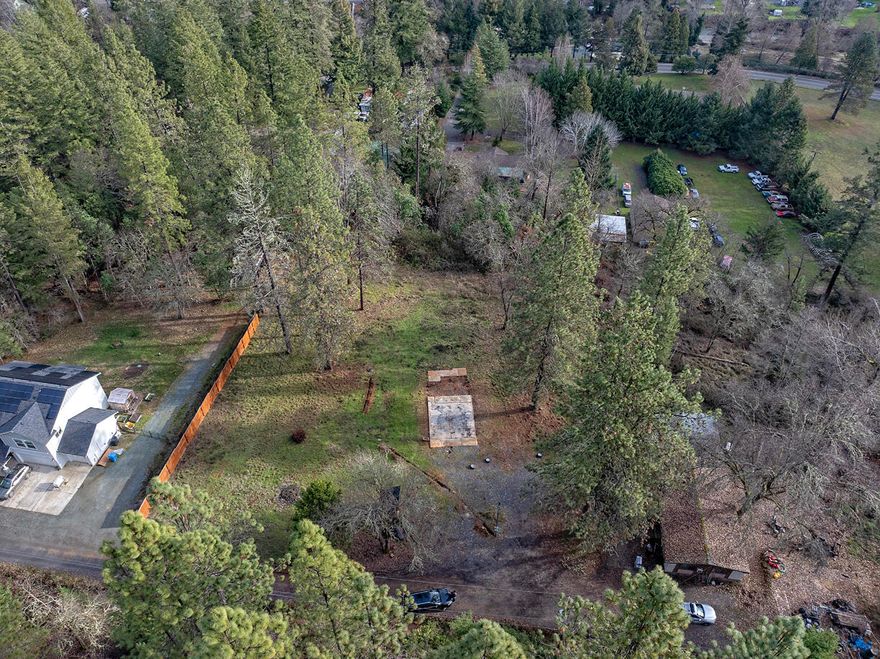 Discover the potential of this hidden gem tucked away off W Evans Creek! This beautiful property offers a prime opportunity for a new buyer to bring their vision to life. With a well and septic system already in place, much of the groundwork has been done. The property previously featured a home that was lost to fire, leaving a cleared and ready-to-build site for your dream home or a manufactured home. Surrounded by nature yet conveniently located, this property provides easy access to downtown Rogue River, just a 5-minute drive away, for shopping, dining, and community events. Plus, with Interstate 5 nearby, you can reach Grants Pass in approximately 10 minutes and Medford in about 20 minutes, making commuting a breeze.