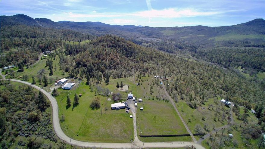 Beautiful usable 7.72 acres just a short distance from town. This 1848 SF has split floor plan with 4 bedrooms 2 baths. Laminate and carpet flooring (newer laminate in the master walk-in, both bathrooms & laundry room). Newer ceiling in the guest bath. Decks out both the front and back of home. Lg gazebo perfect for entertaining, lg fenced garden area, shop is 24x28 & built in 2007 with 220 elect & heater plus half bath (half bath not permitted). Newer 1 room cabin with electricity-has excellent views on the property. 32 GPM well per seller that supplies the needs of the entire property and keeps the large pond full all summer. Newer water heater, dishwasher, lines and pump for sand filter. Plenty of RV parking, close to BLM, lots of wildlife-turkeys, deer, mallards, blue herring, etc right out your backdoor. Great set up for anyone who likes to entertain!