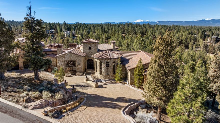 Step inside this remarkable home and be transported to Europe, where every corner tells a story of worldwide inspiration and craftsmanship from another era. With its meticulously curated design, this home offers an unparalleled sense of history and artistry. Perched above Awbrey Glen Golf Course, it
boasts sweeping views of the Cascade Mountain Range. Inside you'll discover an expansive gourmet kitchen, complete with a butler's pantry, formal dining room, wine cellar, an executive office/library, game room with a pool table, shuffle board, game table and a movie theater. The heated tile balcony welcomes you
with ample room for entertaining and savoring the sunsets. Each bedroom has access to the two story balcony, offering elevated views. This exquisite residence is a masterpiece of design and craftsmanship.  A home that must be experienced in person to fully appreciate its beauty and artistry.