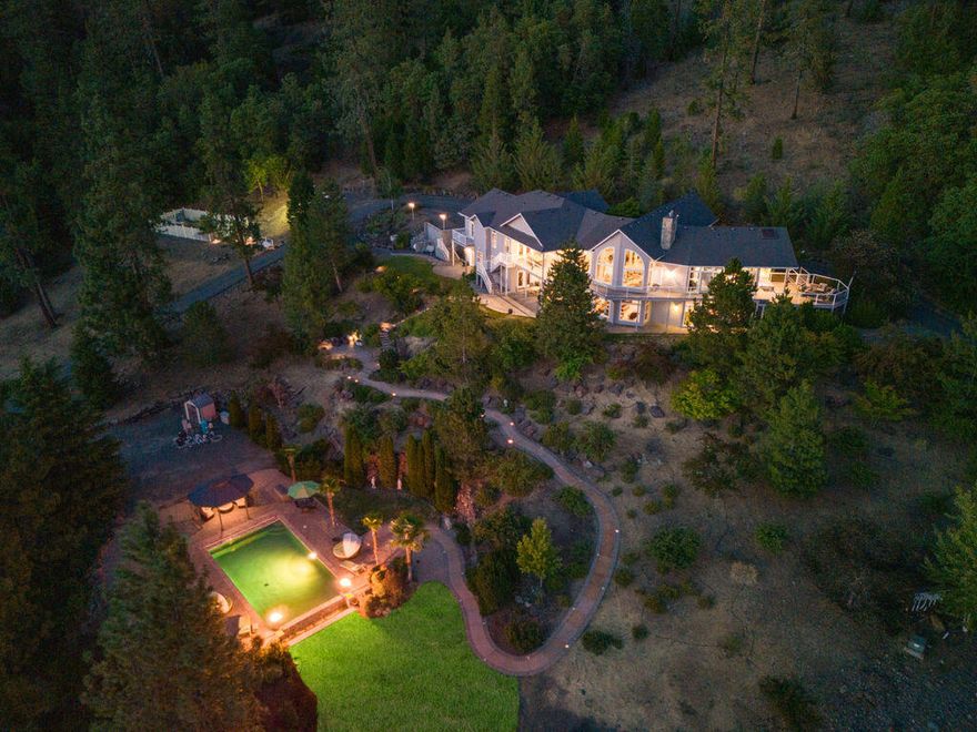 Welcome to Granite Hills Estate. Truly exceptional property. 20 Acres back to BLM & County land, Paved driveway w/gated entry, water feature & year-round spring fed pond w/a dock & Bass fishing. Gorgeous landscaping w/ lighted pathways. 4 Bdrm, 4 bath, Office/Library w/built-ins, 6400 SQ Ft, 3 Car Garage w/Portico.  Grand entry, lg vaulted ceilings, floor to ceiling windows to take in the stunning views of Mts & City lights. Lg kitchen w/island, main floor primary suite w/spa like bath, door to private deck w/hot tub w/skylight & views. Good size bdrms, lg pantry. Downstairs w/10' ceilings, French Doors to covered patios, lg family rm w/fireplace, lg bar & entertaining area w/mini kitchen, Guest quarters w/kitchenette, bedroom, living rm & door to patio. Infinity Pebble Tec heated pool, lg pavers patio w/Gazebo & fire torches. 5600 SQ FT detached Shop w/RV storage w/dump, water & electricity, office space, ½ bath, 4 Car carport. Country living close to town!