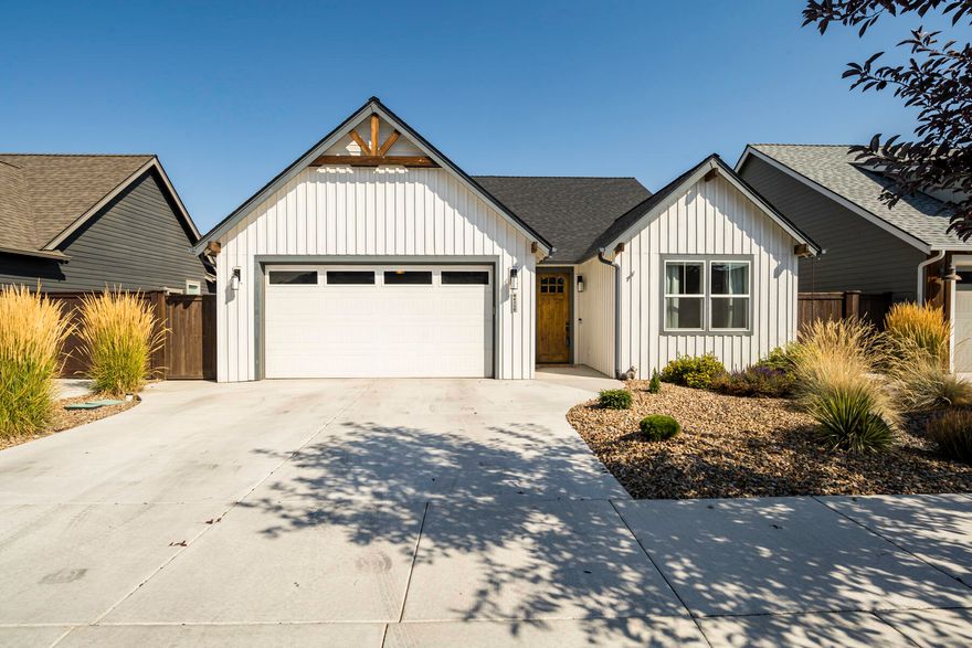 This Earth Advantage-certified home blends modern farmhouse style with sustainability, featuring shiplap exterior, hardwood floors, and a thoughtful single-level floor plan. Cathedral ceilings and a stacked stone fireplace in the living room complement a gourmet kitchen with quartz countertops, center island with granite undermount sink, and soft-close drawers. The primary suite, conveniently separated alongside a home office/den, offers tray ceilings and a bath with dual vanity and heated floors. Energy-efficient features include a tankless water heater, upgraded insulation for improved air quality, and an oversized garage with electric charger, connected by a mudroom. Enjoy a low-maintenance xeriscaped front yard along with a spacious fully-fenced back yard and a covered patio perfect for outdoor dining. Located on a quiet street connected to a private community green space, which includes a dog park and pavilion. 10 minutes to downtown Redmond and the airport; 20 minutes to Bend.
