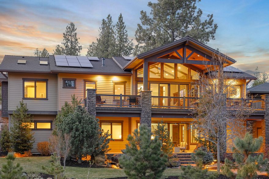 Set within the prestigious Reserve at Broken Top, this 4368 sqft retreat seamlessly blends luxury & landscape. Soaring vaulted ceilings with exposed wood beams frame the grand living area, anchored by a stunning floor-to-ceiling stone fireplace. The chef's kitchen stands as the heart of this home, featuring a massive island, premium Thermador appliances including a built-in coffee system, and custom crafted cabinetry. 5 spacious bedrooms provide abundant room for guests, while 4.5 bathrooms offer spa-like experiences. Custom built-ins & wood accents throughout add sophistication and functionality. Modern luxuries elevate everyday living: dedicated exercise room, heated driveway, dog wash station in the huge 3-car garage, large entertainment room with backyard access and second refrigerator/freezer. Outdoor area features a built-in BBQ, fire pit, water feature, and direct trail access. Fully owned solar provides efficient energy. Rare offering in one of Bend's most coveted communities.