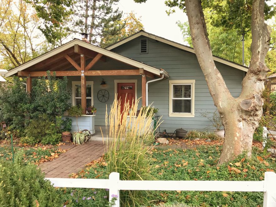 Charming single-level cottage blocks from downtown, parks, and shopping. This 2-bed, 1-bath home features an open floor plan filled with natural light. The living room offers beautiful floors and a cozy wood-burning fireplace, a bright kitchen with breakfast bar and open shelving. Laundry/mudroom opens to a back deck overlooking the backyard with mature plantings and a brick patio—perfect for morning coffee or entertaining. The bedrooms and the bath are tucked away for privacy, and one bedroom opens to the deck. Covered front porch and mature shade trees complete this inviting home. Enjoy the Ashland lifestyle close to parks, trails, and town. Don't miss it!