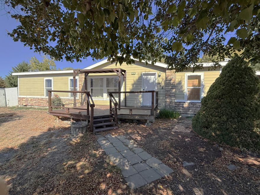 Nicely updated 3 bedroom 2 bath manufactured home on ½ acre lot. This home has an open floorplan with new laminate floors throughout except kitchen and bathrooms, newly painted kitchen and bathroom cabinets, additional certified wood stove for heat, garden tub and walk-in shower in primary bedroom. Dining area leads out to the deck and fenced back yard. Home has an attached carport w/storage and separate storage shed, dog run and plum and apple trees.