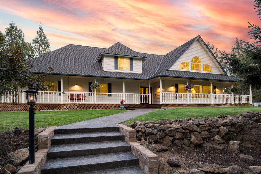 Impeccably maintained private estate on 10 private, park-like acres with 2.9 acres of irrigation rights and mountain views. Hidden from the road by mature trees and natural barriers, yet just minutes to town. Enjoy the expansive wraparound deck with many usable spaces perfect for entertaining. Inside, dramatic beams, vaulted ceilings, a stone hearth with woodstove, and walls of glass fill the home with light. The main level offers four bedrooms and two baths, while the upstairs primary suite includes a sitting room, luxury bath, and oversized closet. A versatile loft/bonus room with deck completes the upper level. Updates include fresh paint, new garage doors, appliances, window treatments, and a fenced garden. Landscaped grounds feature underground irrigation, irrigated pasture with K-Line, rock outcroppings, a pond, chicken coop, and abundant wildlife—making this turnkey property a rare find.