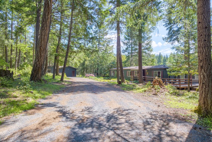 Beautiful private setting on 10+ acres, split into two 5-acre parcels, bordering Josephine County land with access. This 1,782 sq ft home, built in 1980, offers 3 bedrooms, 2 updated bathrooms, living and family rooms with ceiling fans, kitchen with garden window and eat-in bar, dining area and a large laundry room with utility sink leading to a screened-in back deck. Features include 4 mini-splits, certified wood stove, skylights and updated double pane vinyl windows. Outside you'll find a 20x28 shop/garage with 220 power, 10x14 studio, RV parking with hookups, large back deck with hot tub, fire pit and garden area. New roofs on both home and garage. A perfect blend of privacy, space and outdoor lifestyle—ideal for homesteading, recreation, or quiet living. A 5 minute drive to beautiful Lake Selmac.  Don't miss out on everything this property has to offer.