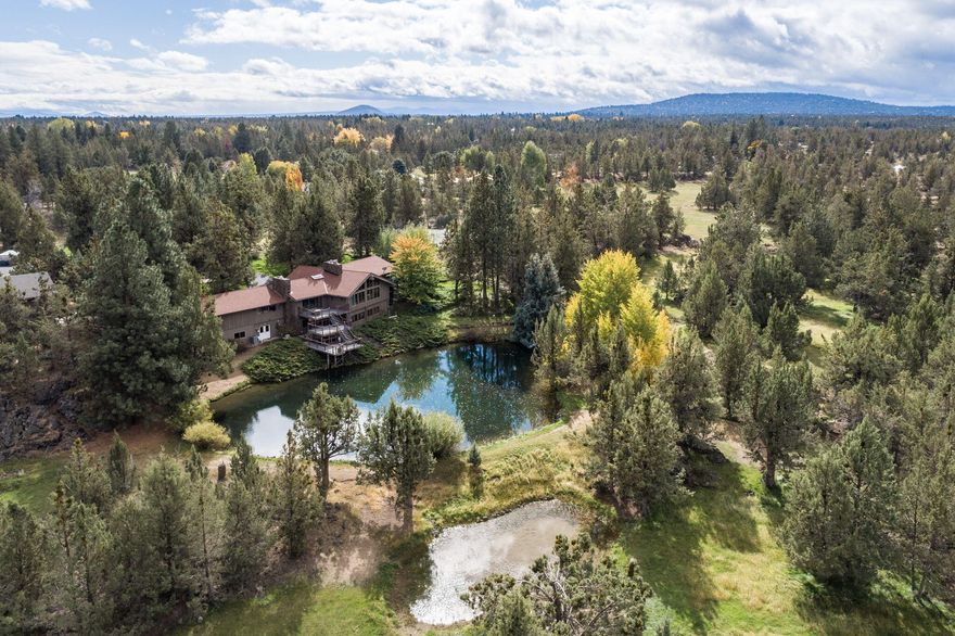 Welcome to ''Sunshine Daydream'' estate, this special property is in Bend's desirable Tumalo area and is a true masterpiece. Situated on 2 tax lots, this 13.85-acre property (9.7 acres of Swalley Irrigation) includes two ponds, a 3-stall barn, 36x36 ft shop with RV parking, tennis court, and greenhouse.  

The Italian inspired home welcomes you in with dramatic, vaulted-wood ceilings and expansive bay windows that frame the view of the surrounding mountains. The high-level of craftsmanship throughout the home includes custom cabinetry and solid slab granite counter tops and beautiful Travertine tile flooring. The exquisite primary ensuite has custom walk-in closet as well as floor to ceiling walk in shower with a solarium and private deck. Four fireplaces, and oversized office, large family room and spacious mother-in-law suite with private entrance make this home a wonderful option for multi-generational living. 

This beautiful, private, treed property is waiting for you.