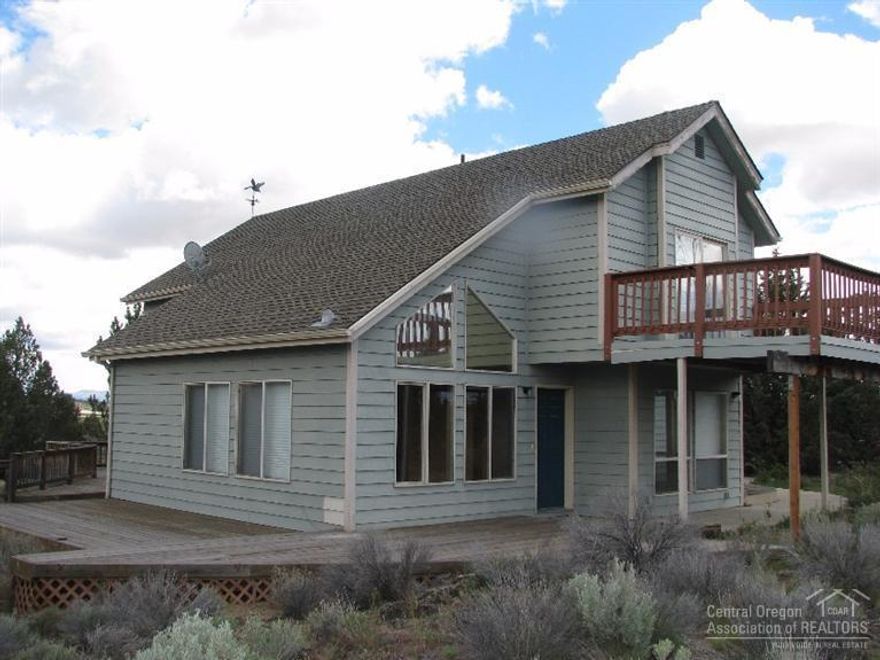 Fenced-gated drive leads to this stylish home on 5.8 acres +/-. Located on paved road near Brasada Ranch in Crook County. Stylish home features open vaulted living area w/ wood floors, windows all around for lovely views in every direction. Attached double garage plus other outbuildings such as barn/shop, storage shed, small greenhouse. Small seasonal canal flows along the roadway in front, very picturesque. Home is privately situated on level land up-hill away from the road with pretty views. Call now.