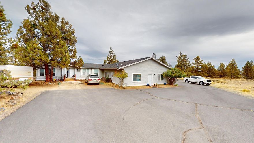 Come home to this expansive ADA accessible home located on 2.28 acres with stunning sunrises & easterly views. Centrally located between Bend and Redmond with easy access to Hwy 97. Main home features 2,404 sq. ft. with 3 beds, 2 baths and a large office/den area. Large family room, dining room and separate living room surrounding expansive kitchen with tons of storage. Large primary suite with double closets and double vanities. Double sliding glass doors and huge windows allow tons of natural light to flow throughout the home. Half of the 1,280 sq. foot attached garage has been converted to a 640 sq. ft 1 bed/1bath apartment currently renting for $700/mo. with private entrance. Exterior features asphalt driveway, extensive RV/toy parking, 16x60' rear deck great for entertaining. Buyers must review 3-D walkthroughs of main home and apartment prior to scheduling a showing. 3-D links attached to listing.