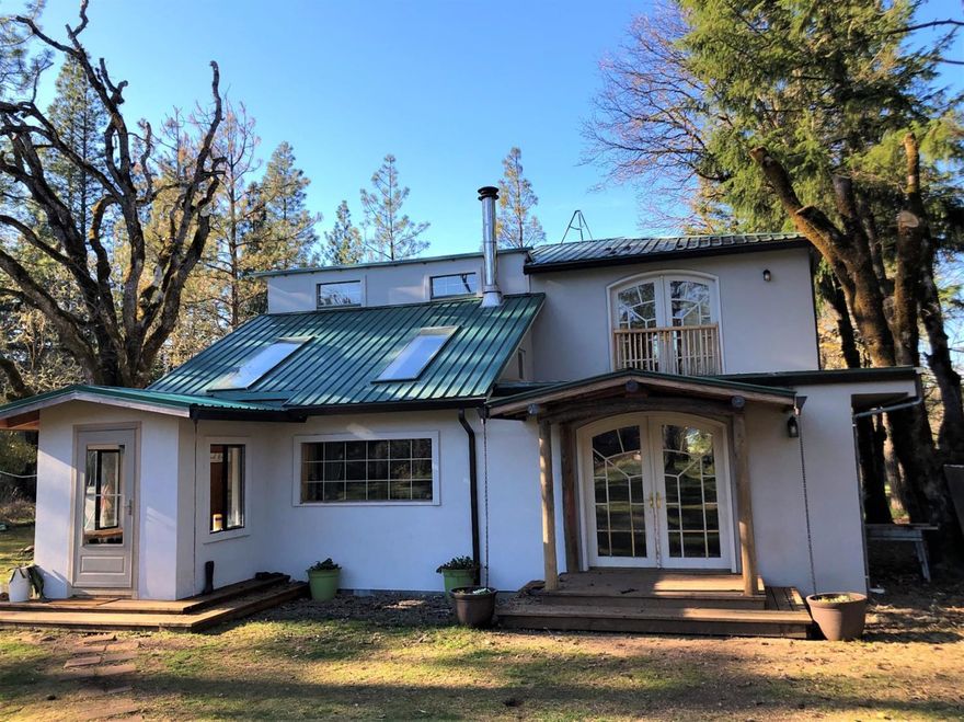Find all the Oregon charm in this mountain cottage home in downtown Takilma. Enjoy an amazing view of Hope Mountain out your front door. There's plenty of sun, water and flat for gardening opportunities. The exterior of the home features stucco siding and metal roofing. It's a long lasting pleasing aesthetic as well as functional for fire prevention. The front entry has a coat room that opens to the bright large dining room and living room area. There are wood floors throughout the house, new drywall on the main floor and knotty pine decorates one bedroom and the upstairs office. The Master bedroom is on the second floor with large french doors to outside. Come see this homestead option, this quiet sunny flat by the forest. Property may also be available for a year long lease at $60,000