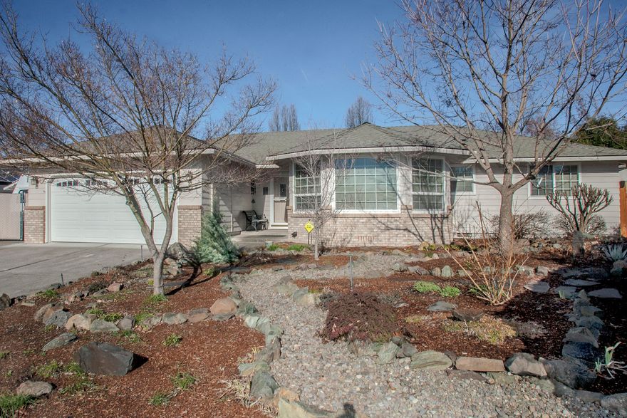 Beautiful, light & open, turnkey WL Moore home in desirable East Medford neighborhood. Awesome kitchen remodel (2020) with leathered granite countertops, canned lighting, solar tube, breakfast bar on the island, utility sink; well-planned storage with soft touch drawer slides, pull-outs, spice cabinets, pantry, etc. Large tiled-floor dining room open to kitchen. Enjoy the outdoors from the lovely sunroom that provides additional living space (9.5'x24' not included in 1734sf) - heat, air conditioning, windows all around. Spacious backyard is a bird sanctuary with a pondless 2-stream waterfall. Darling backyard gazebo for outdoor entertaining. Detached workshop (10'x10') currently used for a lapidary studio--fully insulated. Tool shed (6'x8'). Newer backyard fencing. Gated concrete RV parking (10'x39'). Insulated 504sf (per assessor) garage. New carpet & exterior paint in 2020. Updated vinyl windows. Plumbing updated to Pex. Washer, dryer & refrigerator included. 1-yr home warranty.