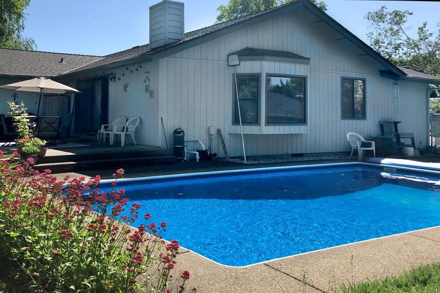 Charming East Medford home with delightful in-ground pool and east-facing patio--excellent for outdoor living and entertaining! Located in a quiet cul-de-sac just a few blocks from Lone Pine Elementary. Spacious great room with vaulted ceiling, beautiful wood flooring and free-standing corner gas stove; overlooks the pool and is just steps away to the peaceful relaxed backyard. Roomy master suite is tucked away at the back of the home. Large RV parking (45'x16'). Dog-friendly fenced yard including a good-sized dog run alongside the home. Home's location has great access to amenities. Move-in ready. Seller will purchase a one-year home warranty.