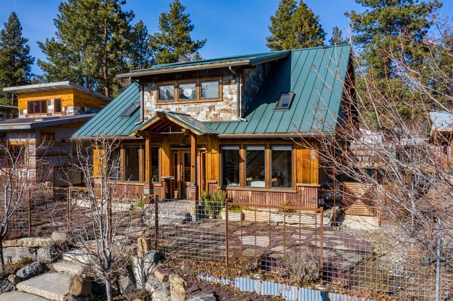 Sustainably constructed with attention to detail in every aspect. This one of a kind mini-estate is nestled on a .23 acre double lot on Bend's westside. Your green thumb will delight with the bountiful orchard complete with a seasonal fruits, flowers, berries, & hops. Relax under the covered paver patio while enjoying the trickling water feature & custom chicken coop. Enter this Earth Advantage home through the historical copper doors from the old Bulletin site. Artistically intriguing elements throughout including front entry reclaimed beams from a lumber mill in Dunsmuir to a stair case that was reclaimed from the chassis of a Winnebago. The main level cement floor is specifically designed in conjunction with the front windows to harvest the sun & redistribute the heat throughout. Outstanding open floor plan with main level master & second story bonus room. Complete with detached garage with second story ADU. This is truly a special home.