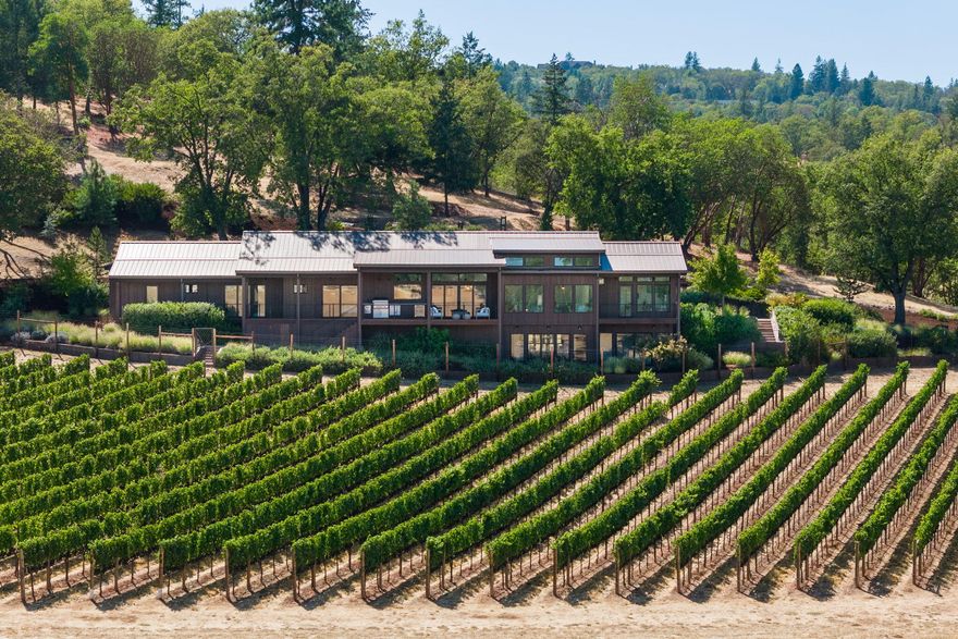 Welcome Home, to the Vineyards at Stage Pass. Wine Country-Inspired, Rustic Modern  home , features a spacious light-filled open floor plan, at 3833 sqft includes four bedrooms, 3.5 baths designed to capture the beauty of the landscape, vines and valley. The Chef's kitchen is surely to impress with top of the line Wolf and Sub-Zero appliances. The luxurious master suite exits to the spacious covered South American Borneo Mahogany deck and what could be a private hot tub area. The main floor also boasts a second suite, as well as a fourth bedroom or office. Flooring throughout features European white oak wide-plank hardwood, with Ann Sacks tile in the wet areas. Downstairs you will find a guest suite, wine tasting room and a temperature-controlled wine cellar. Exterior features include gables, pitches, and vertical cedar siding. Designed for year around entertaining the nearly 1,000 sqft covered deck offers a built-in Wolf grill and fire pit overlooking the home's backyard vineyard