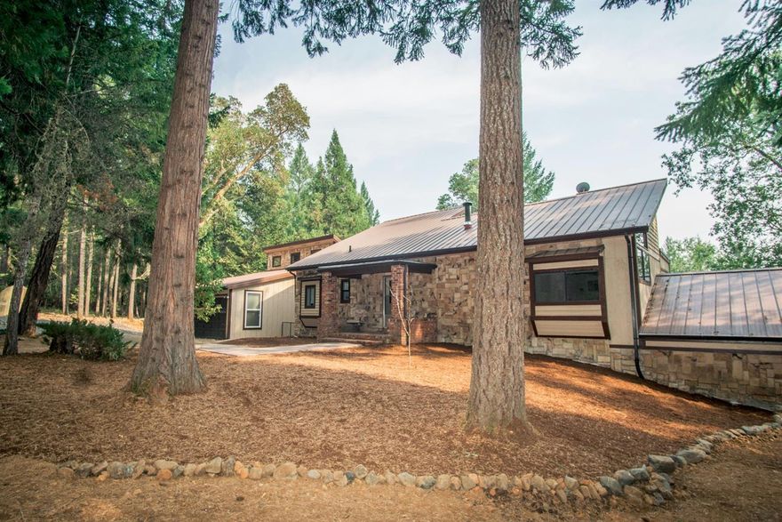 Privately set on 7.48 acres, this custom home has beautiful views & is located just a relaxing walk to year-around Deer Creek at the south end of the property. The home has an abundance of natural light with large windows throughout the main level. The living room features huge vaulted ceilings with wood beams & knotty pine, a cozy reading loft, a second bonus loft with private deck, & picture windows that showcase the view! There's a large dining room for hosting family gatherings or use as a second living space. Kitchen features include tile counters & a nice eating bar that opens to the breakfast area. An elevator carries you to the sleeping areas & master suite (there is a staircase, as well). The 2-car garage also has an additional workshop attached with its own garage door for moving large projects in & out. There is a generator & a walk-behind brush-hog included. The property is mostly wooded but features ample level area for parking toys or having a garden.