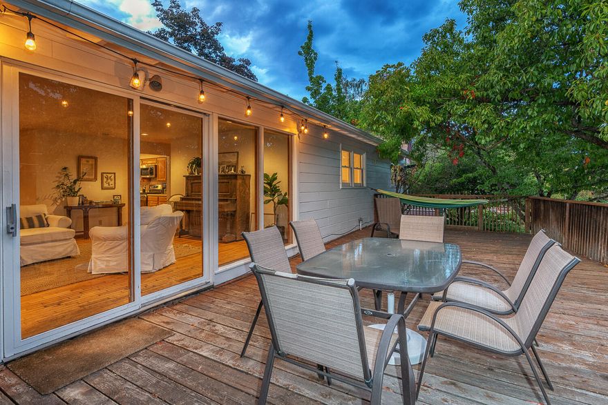 Private single-level view home sited on corner lot above the boulevard within a half-mile of the Ashland Public Library. Features include floor-to-ceiling windows, hardwood oak floors, a gas fireplace with granite hearth and rustic wood mantle, and a spacious garage with workshop space. The kitchen is outfitted with extensive wood cabinetry and a large window above the sink overlooking the side yard. This home has wonderfully sunny bedrooms, and a spacious bathroom with large linen closet. Outside you'll find an expansive deck with views of Grizzly Peak and the Cascade Mountains, covered brick patio, Mimosa tree, giant Japanese maple, wisteria, drip irrigation, and Oregon moss rock terracing. Recent updates include a newer roof, newer gas furnace, and fresh exterior paint.